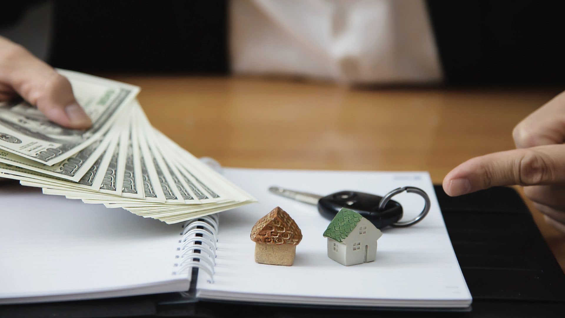 Cash Offer for House Keys - We Buy Houses Cash Cash offer with house keys and miniature home model on table.